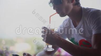 戴太阳镜的年轻人在咖啡馆的花园里使用手机和喝鸡尾酒。 <strong>1920</strong>x1080